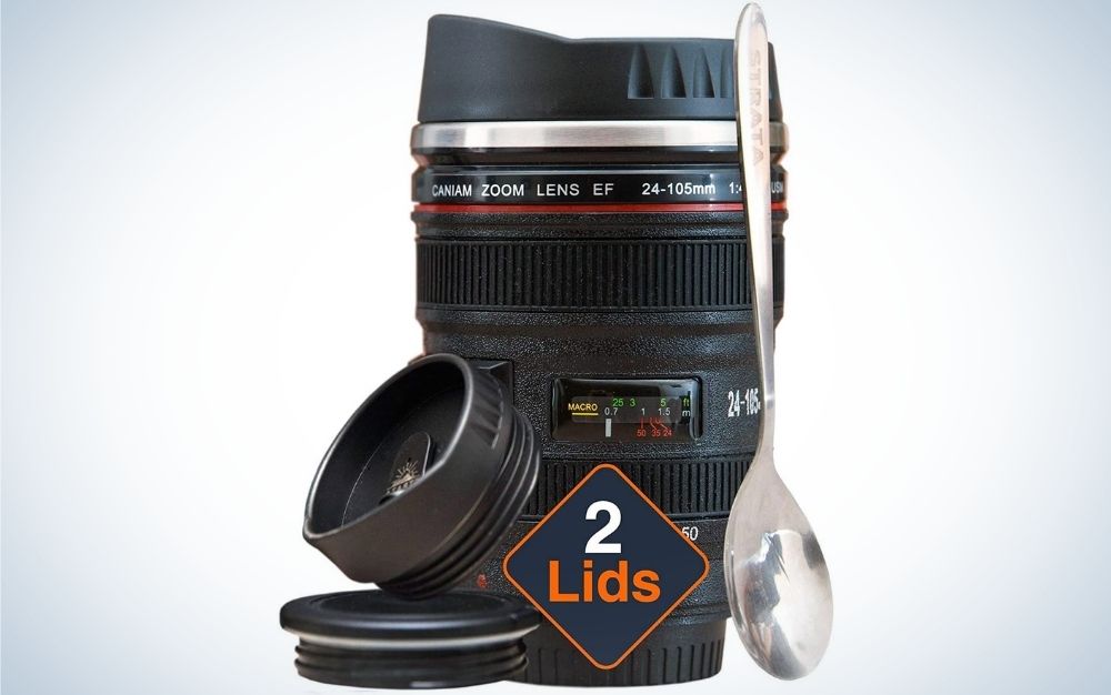 相机镜头咖啡杯写在它的前面2个盖子和勺子在它的前面。