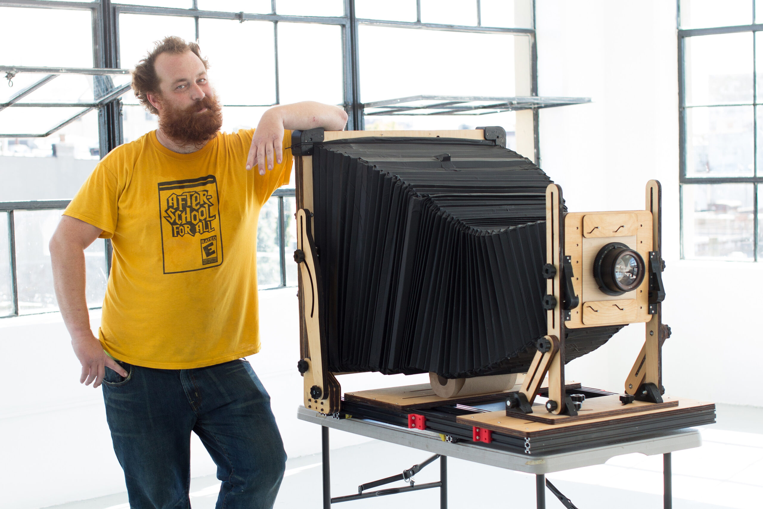伊森·摩西站在自制的巨型即时相机旁。