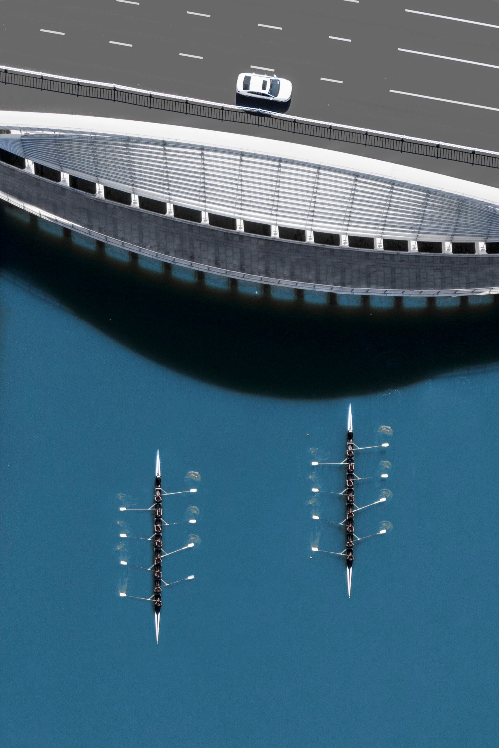 两艘划艇向一座桥划去。