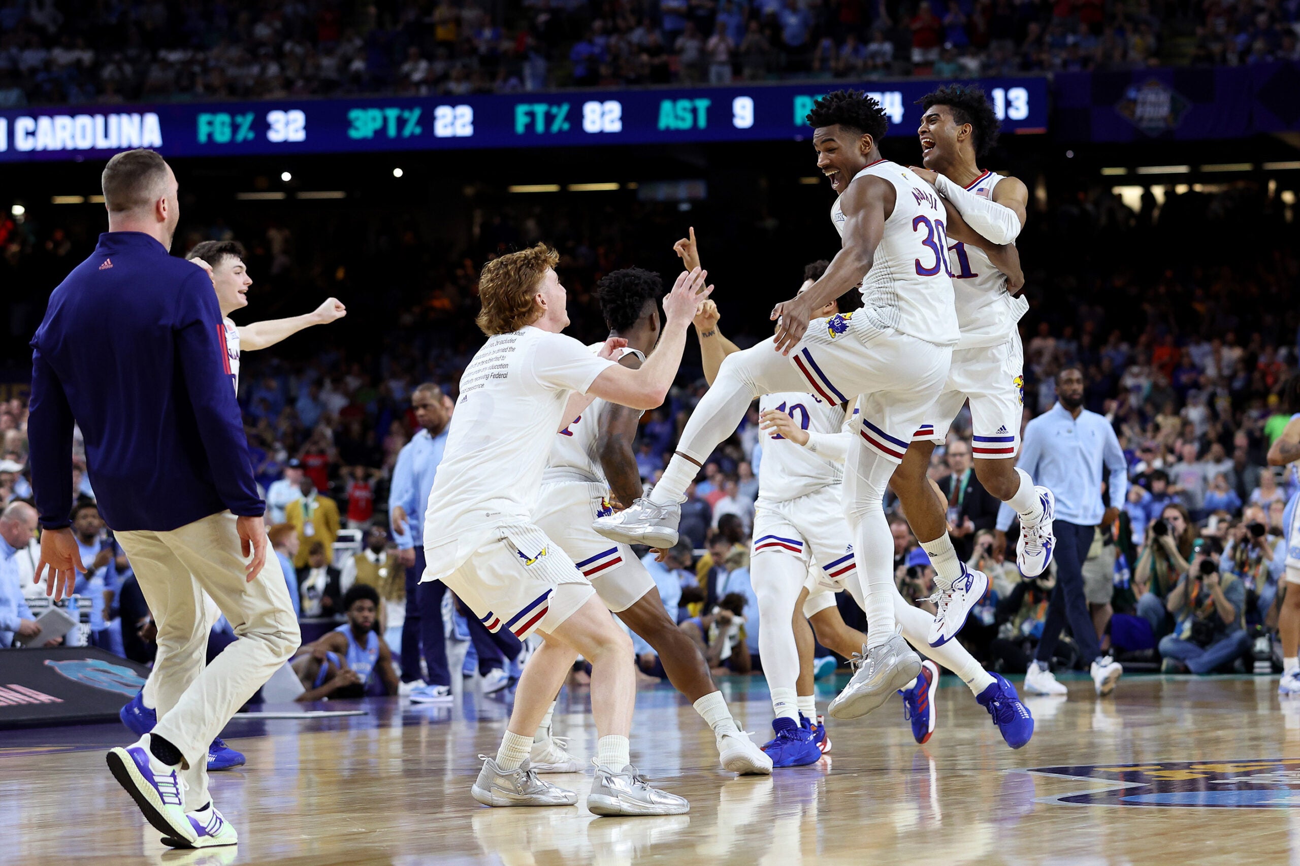 堪萨斯输给球员庆祝击败北卡罗来纳州的焦油脚跟后72 - 69年期间2022 NCAA男子篮球锦标赛全国冠军。